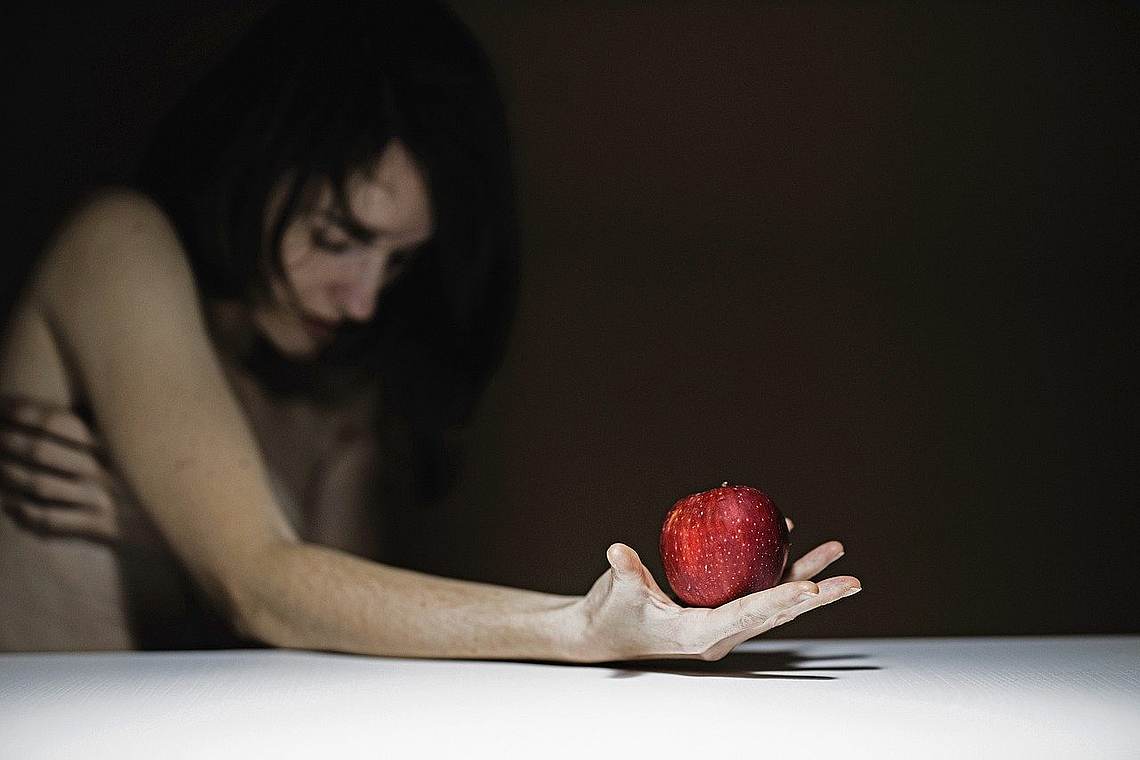 Essstörung - Frau mit Apfel in der Hand